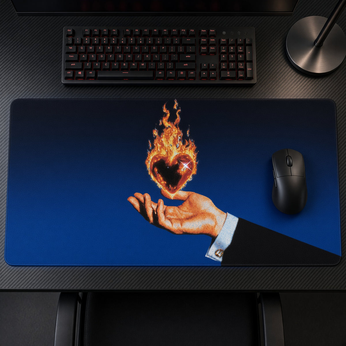 Flaming Heart in Hand Playmat on a gaming desk, top-down view