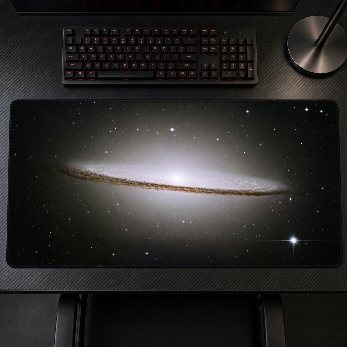 Sombrero Galaxy M104 (Hubble) Space Playmat on a gaming desk, top-down view